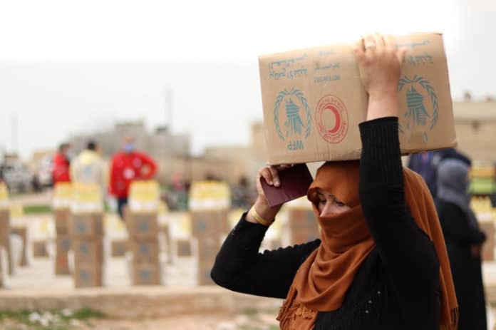 En kvinde henter madrationer i Deir Hater, 60 km fra Aleppo, Syrien. FOTO: WFP / Alissa Khudr