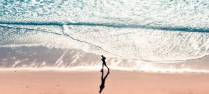 Mand løber langs en strand