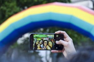 Et selfie taget foran en falsk regnbue