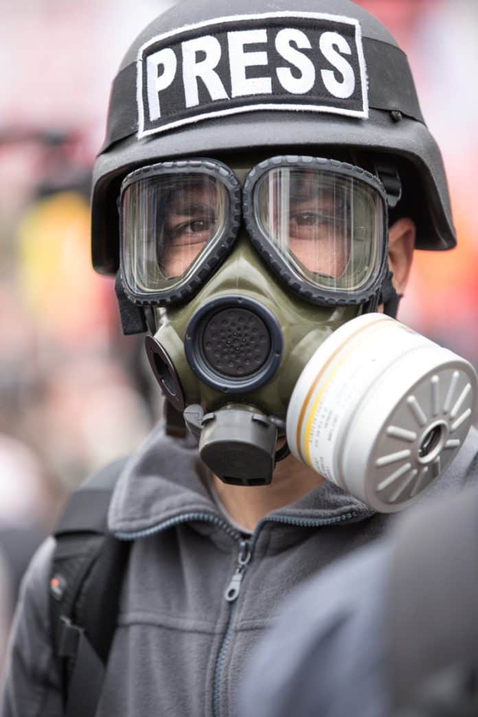 journalist with gas mask