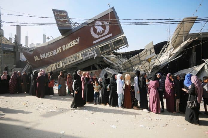 People standing in line in front of a bakery in Gaza