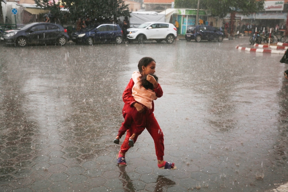 Children in the pouring rain in Gaza