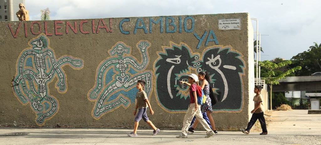 Børn går foran en mural i Caracas. Foto: UNICEF/Velasquez