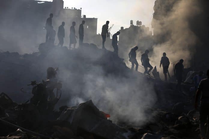 Billedet viser flygtninger der kæmper sig gennem murbrokkerne i Gaza