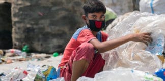 Twelve-year-old boy in Dhaka, capital of Bangladesh, sorts through hazardous plastic waste without any protection, working to support his family amidst the lockdown.