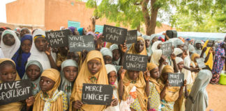 Young girls in the village of Danja in Niger hold signs in support of the Spotlight Initiative