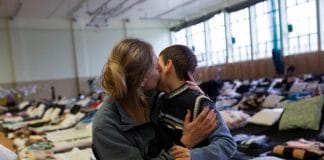 A refugee from Ukraine hugs her son in a reception centre set up in the sports hall of a school in the Polish border town of Medyka.