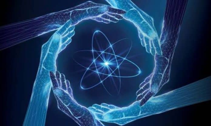 Image of an atom surrounded by hands