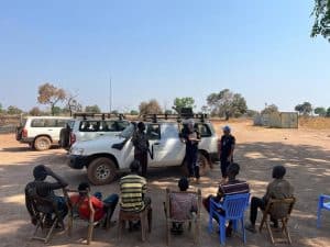 “One takes what one gets”: training with SSNPS (South Sudanese National Police). In the absence of a classroom, the shadow under a tree and the patrol car act as classrooms.
