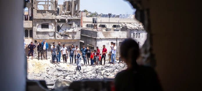 Local people look at damage to a residential community in Gaza.