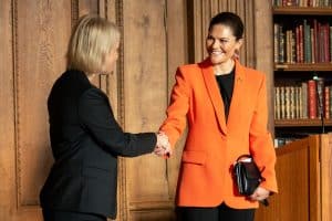 Two women shaking hands in a formal setting