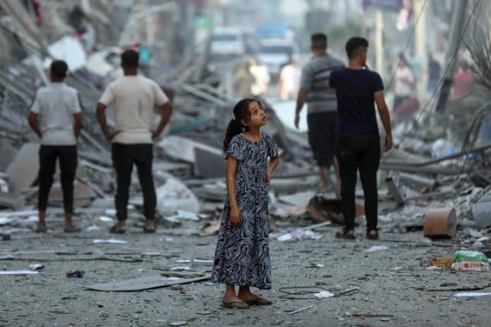 Amal, 7 years old, contemplates her neighbourhood after neighbouring homes were levelled to the ground in Gaza