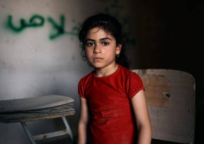 Tabarak, 6, Iraq. Tabarak lives in the war-torn western district in the old city of Mosul. She sits in an empty classroom at Al-Ekhlas primary school in the Nabi Jarjis neighbourhood.
