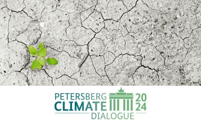 Petersberg climate dialogue logo on top of climate change image of dried lake