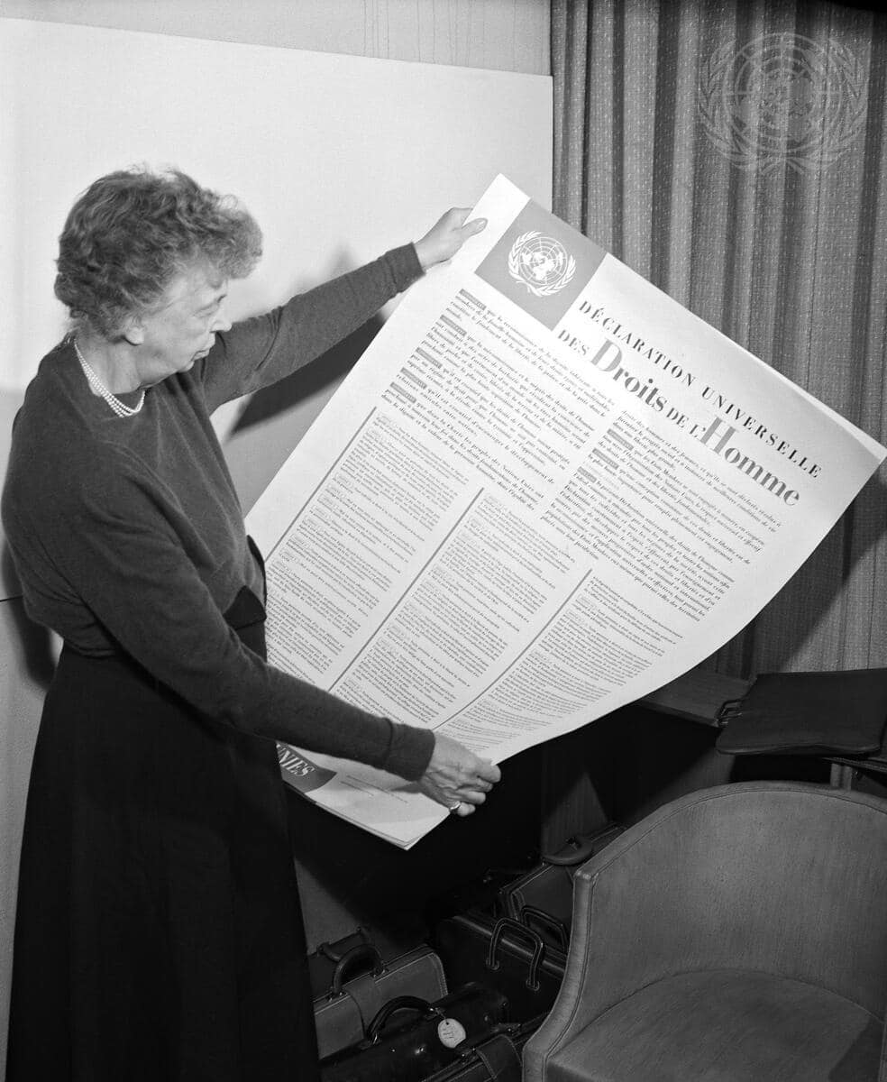 Eleanor Roosevelt of the United States holding a Universal Declaration of Human Rights poster in French.