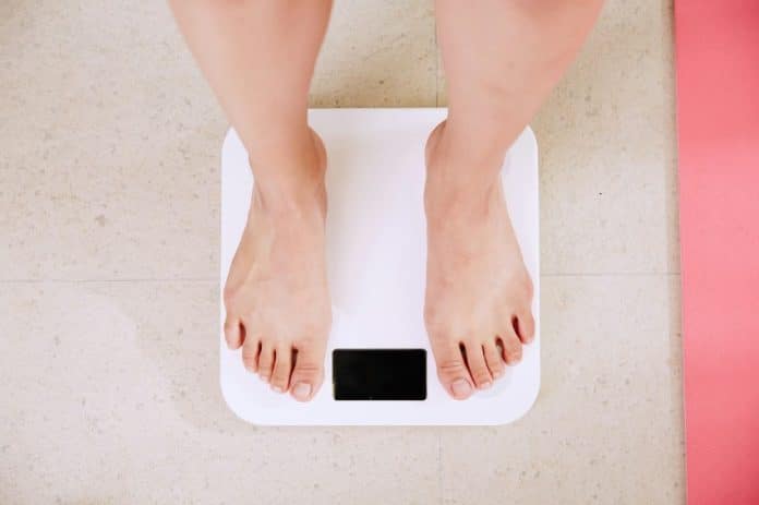 Person on scales © Photo by i yunmai on Unsplash