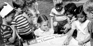 Niños miran un póster de la Declaración Universal de los Derechos Humanos