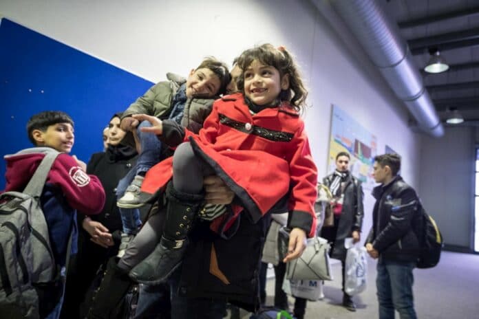 Un hombre sirio espera en la línea, junto a su hija e hijo en el aeropuerto de Hanover