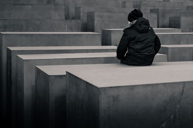 Joven sentado en el monumento judío de Berlín