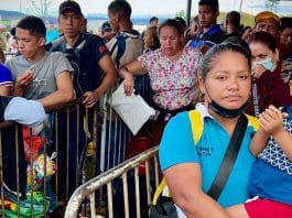 Madre con hijo-migrantes-venezolanos hacen fila-Pacaraima- frontera Brasil