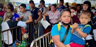 Madre con hijo-migrantes-venezolanos hacen fila-Pacaraima- frontera Brasil