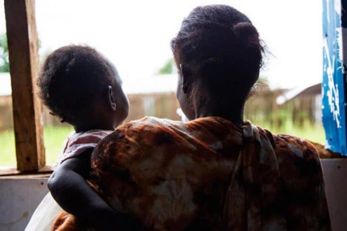 A victim of domestic violence with her child in South-Sudan.