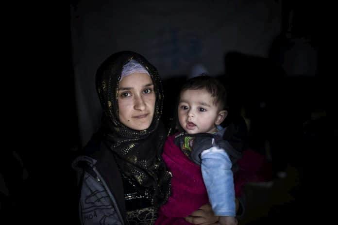 Hakima, 21, holds her four-month-old baby, Jad, at Bar Elias refugee settlement in Lebanon