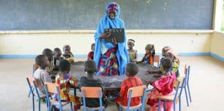 Lapset istuvat opettajansa ympärillään Barin Badjinin kylässä, Nigeriassa