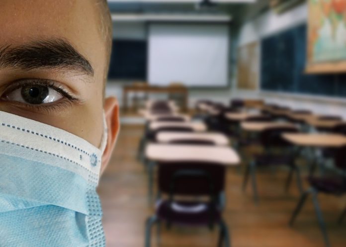 jeune portant un masque dans une salle de classe