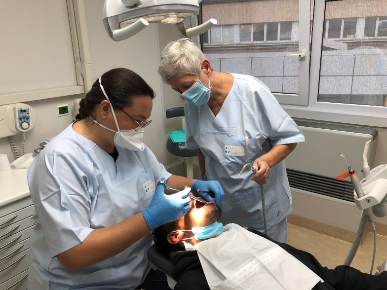 Maggy, 68 ans, bénévole en dentisterie chez Médecins du Monde, avec un patient dans le cabinet dentaire © Médecins du Monde Luxembourg