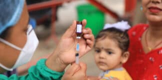 Des agents de santé dans un centre de vaccination à Kalanki, dans la capitale du Népal, Katmandou, se préparent à administrer le vaccin contre la rougeole et la rubéole aux enfants amenés par leurs parents, le 2 juillet 2020.