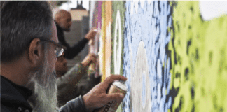 Graffeurs en train de réaliser une fresque murale