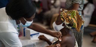 femme africaine se faisant vacciner par une infirmière locale