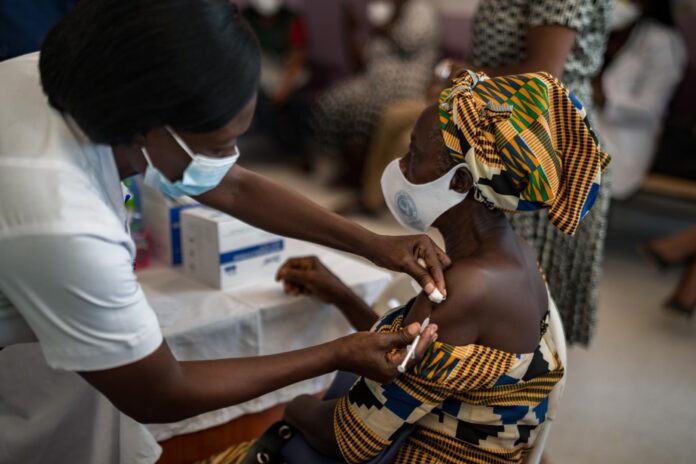 femme africaine se faisant vacciner par une infirmière locale