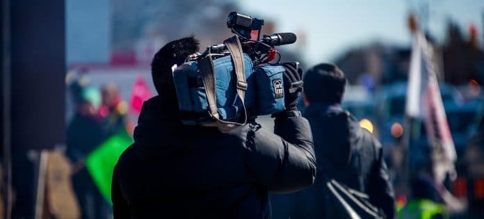 Journaliste de télévision, caméra sur l'épaule