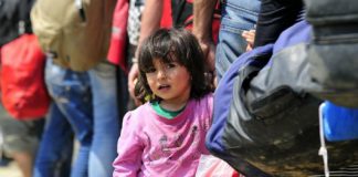 Petite fille dans un groupe de migrants