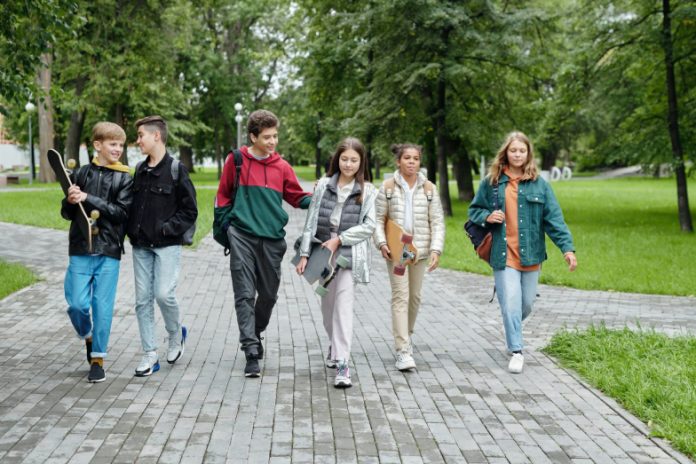 six adolescents qui marchent en riant.