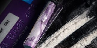 De la poudre de cocaïne sur une table avec un billet enroulé