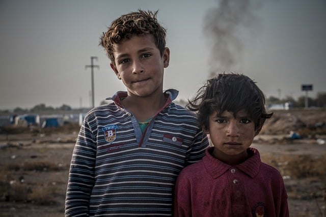 deux enfants face caméra devant un paysage dévasté