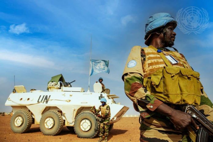 casques bleus devant un char portant les couleurs de l'ONU