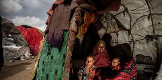 Une mère et ses enfants posent pour une photo dans leur abri temporaire dans un camp pour personnes déplacées. Somalie 2022