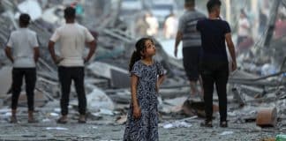 Une jeune filel devant les décombres d'un immeuble à Gaza
