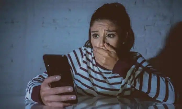 femme au téléphone qui subit violence numérique