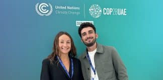 Victoria et Johan posant devant une affiche de la COP28 à Dubaï.