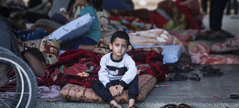 enfant à Gaza assis dans un abri de fortune
