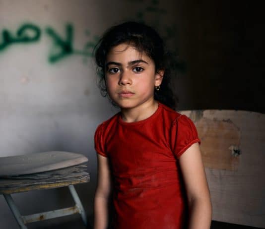 Tabarak, 6 ans, Irak. Tabarak vit dans le quartier ouest déchiré par la guerre, dans la vieille ville de Mossoul. Elle est assise dans une salle de classe vide de l'école primaire Al-Ekhlas, dans le quartier de Nabi Jarjis.* © Paddy Dowling