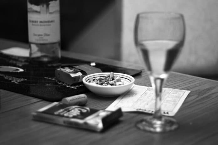 Verre de vin et paquet de cigarette sur une table