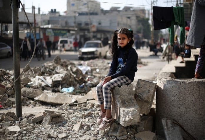 imag d'une enfant devant un batiment détruit. Les armes ne se sont toujours pas tues à Gaza
