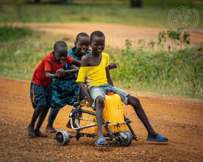 un groupe d'enfants transportant un bidon d'eau au Sud Soudan