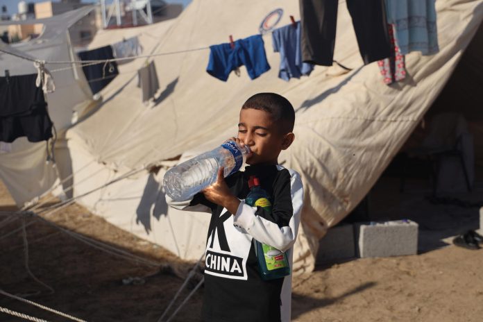Majd Abo Ahaqffa, níu ára gamall drengur frá Biet Hanoun drekkur af vatnsflösku, frá UNICEF.